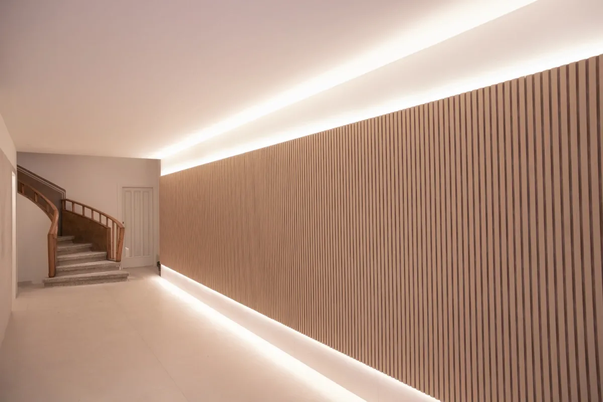 Reforma de Portería en L'Eixample. Pared con lamas de madera y escalera de madera